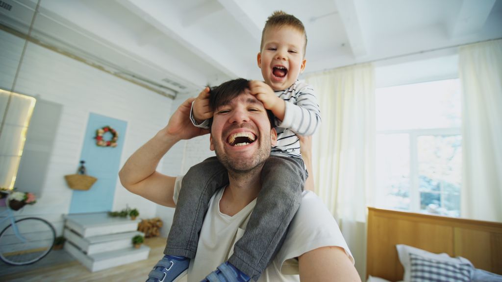 Father and son enjoying playful moments indoors, capturing joy and love.