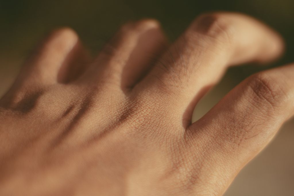 Macro shot of a human hand focusing on skin texture and pores in natural light.