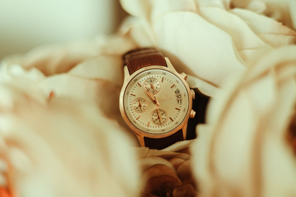 A close-up of a wristwatch encased in delicate, soft-toned flowers, perfect for fashion and elegance themes.