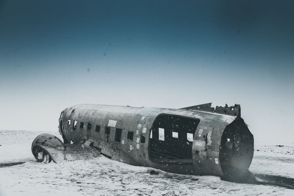 Old weathered aircraft after disaster on snowy land under sky in winter in daytime