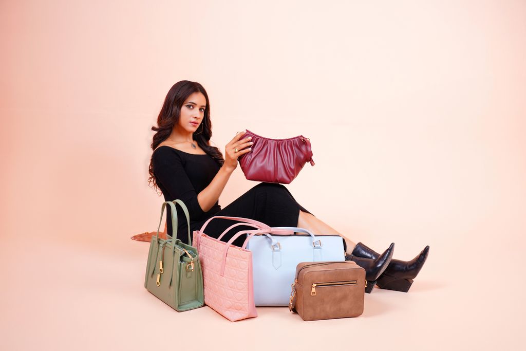 Stylish model showcasing a collection of designer handbags in Lahore.